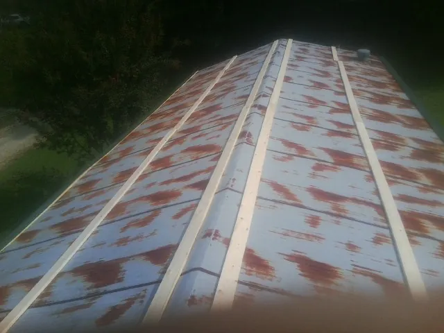 Rusted metal roof panels with new wood purlins before replacement — Storm Damage Roof Repair in Egan by Roofing Brothers