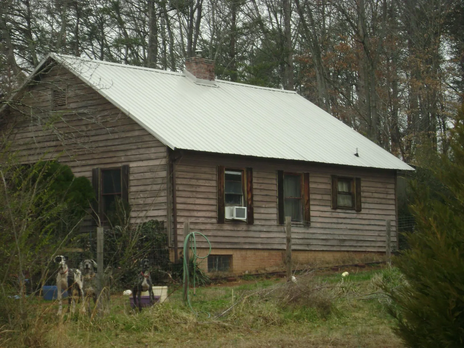 White metal roof on an old wood sided farmhouse, from a Metal Roof Installation job in Egan